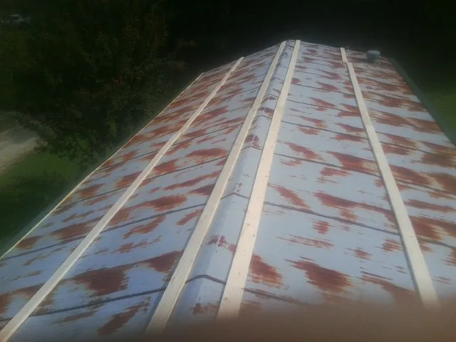 Rusted metal roof panels with new wood purlins before replacement — Storm Damage Roof Repair in Belews Creek by Roofing Brothers