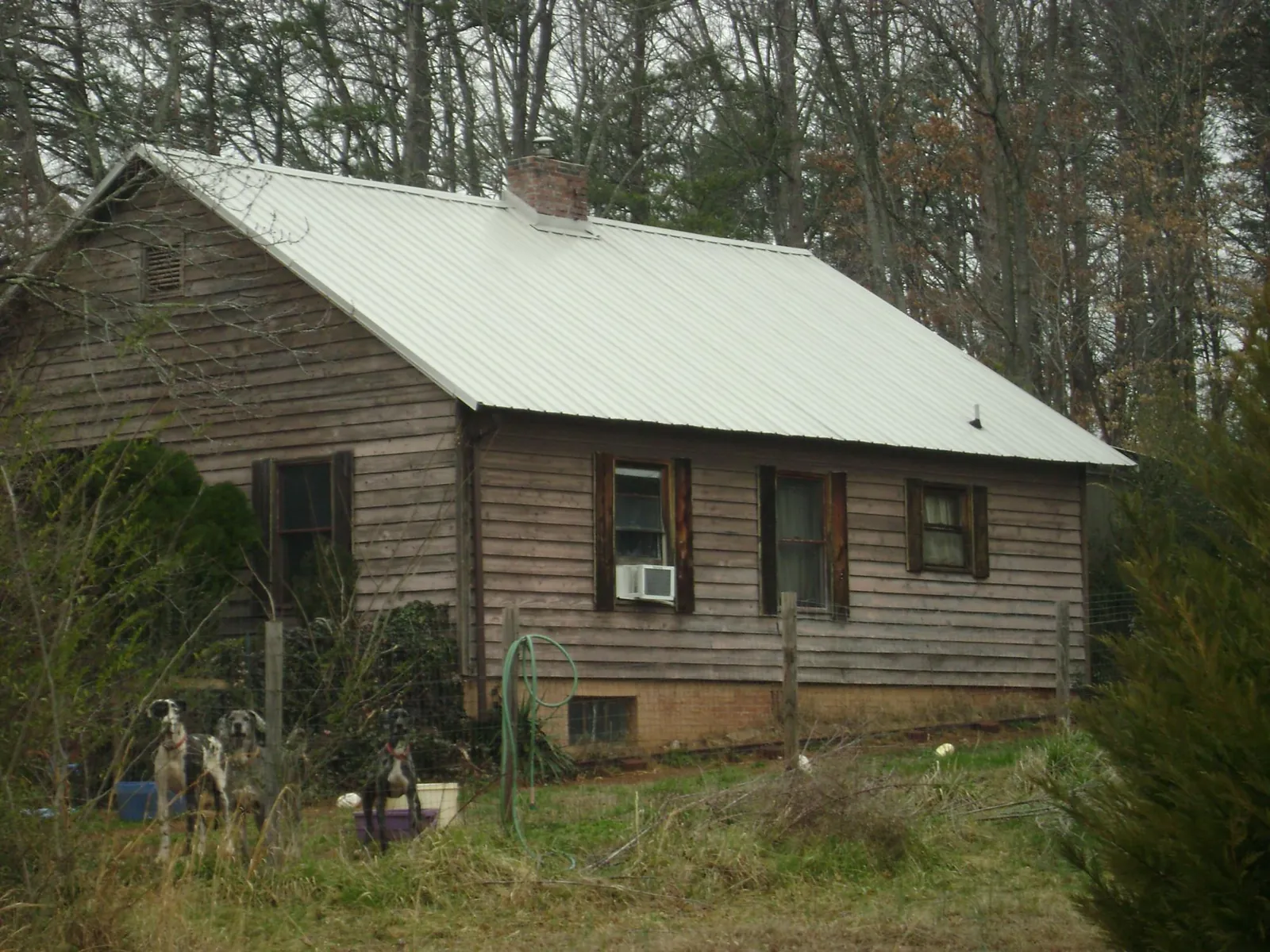 White metal roof on an old wood sided farmhouse, from a Metal Roof Installation job in Belews Creek